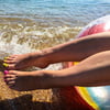 Barefoot wet and wrinkled feet of Mistress on the sea beach